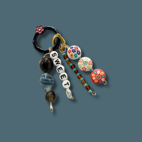 Colorful keychain with beads and charms on a blue background