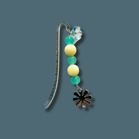 Decorative bookmark with beads and a flower charm on a blue background