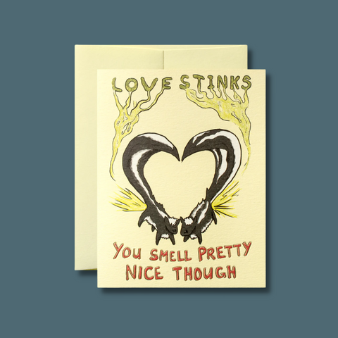 Two skunks with tails in a heart
