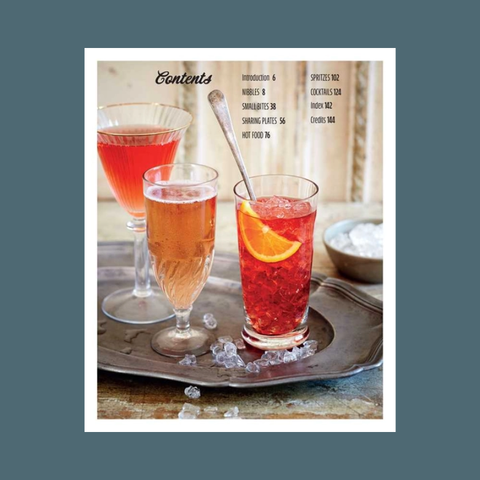 Cocktail glasses with drinks on a tray, featuring a magazine or book layout.
