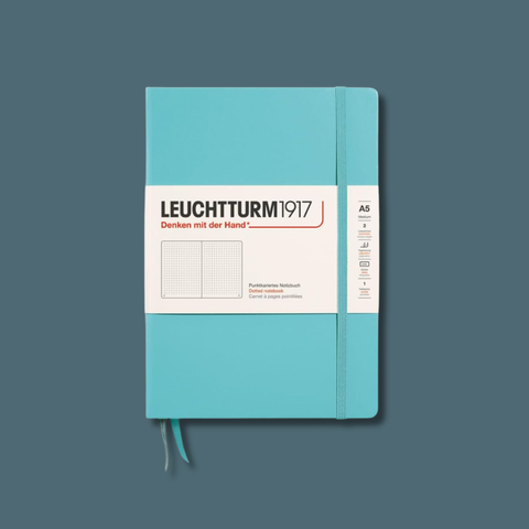Turquoise notebook with Leuchtturm1917 label on a dark blue background