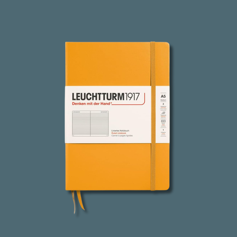 Orange notebook with Leuchtturm1917 branding on a dark blue background