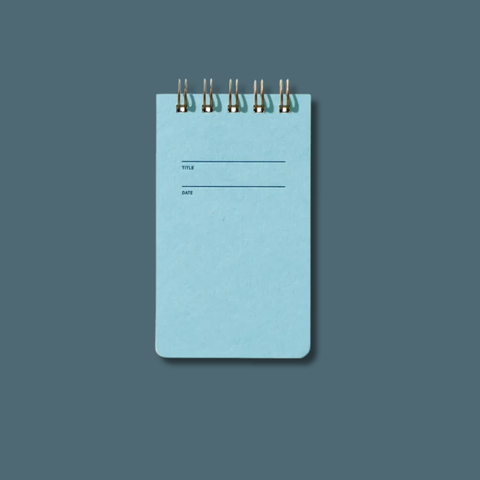 Blue notebook with wire binding on a solid blue background